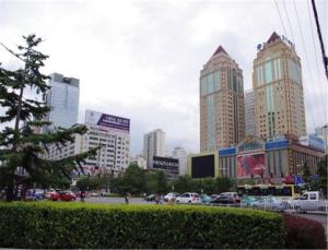 una ciudad con edificios altos y un aparcamiento con coches en 7Days Inn Lanzhou Nanguan en Lanzhou