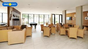 a lobby with chairs and tables and a piano at Double G Resort Anyer in Babagan