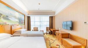 a hotel room with two beds and a flat screen tv at Vienna Classic Hotel Qingdao Huangdao in Huangdao +55 photos
