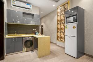 a kitchen with a washer and dryer and a refrigerator at Grand Residence in Riyadh