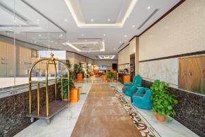 a lobby of a hospital with blue chairs and plants at Grand Residence in Riyadh