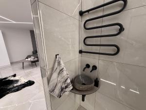 a bathroom with a shower with a bowl on the wall at JE downtown suite in Jelgava +26 photos