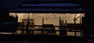a house with christmas lights hanging from it at night at Domek na Folwarku z jacuzzi in Tarnawa Dolna