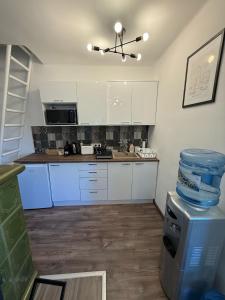 a kitchen with white cabinets and a counter top at Offline vendégház in Orfű