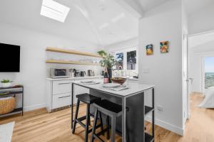 eine Küche mit einer Theke und einem Tisch mit Stühlen in der Unterkunft Bay View Bungalow in San Diego