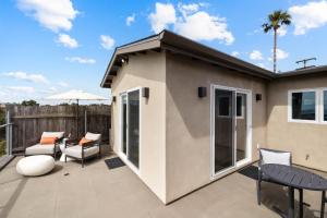 ein Haus mit einer Terrasse mit Stühlen und Tischen in der Unterkunft Bay View Bungalow in San Diego