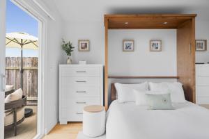ein Schlafzimmer mit einem weißen Bett und einer Kommode in der Unterkunft Bay View Bungalow in San Diego