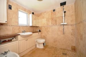une salle de bain avec toilettes, lavabo et douche dans l'établissement Lord Rod's Guest House, à Staines