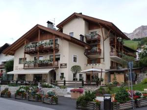 um edifício com varandas e flores em frente em Chalet Ciasa Alexander em San Cassiano