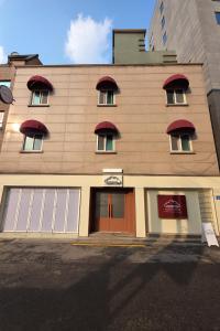 un gran edificio con puertas y ventanas rojas en Self-service Hotel Cozy 10, en Seúl