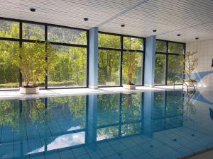 an empty swimming pool with glass windows and trees at Jutta Deluxe Appartement in Bad Reichenhall