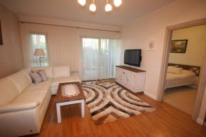 a living room with a couch and a tv at Apartament Bryza in Jurata