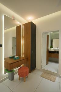 a bathroom with a vanity and a mirror and a stool at 6 BHK Serviced Apartment beside Kolencherry MOSC Hospital in Kadayirippu