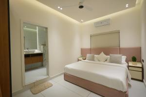 a bedroom with a large bed and a bathroom at 6 BHK Serviced Apartment beside Kolencherry MOSC Hospital in Kadayirippu