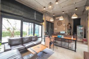 OYO 75368 Demadre Resort في بانكوك: غرفة معيشة مع أريكة وطاولة