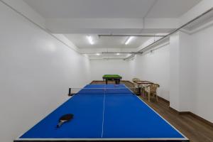 Una gran mesa de ping pong azul en una habitación. en Echor KC Grand Kufri, en Fagu 43 fotos más