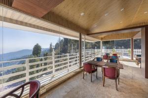 Un comedor con mesa y sillas en un balcón. en Echor KC Grand Kufri, en Fagu