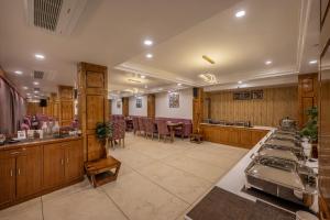 un restaurante con barra con mesas y sillas en Echor KC Grand Kufri, en Fagu