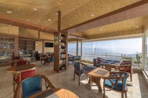 Un restaurante con mesas y sillas y vista al mar. en Echor KC Grand Kufri, en Fagu