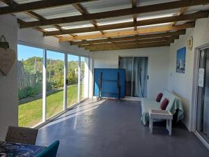ein Wohnzimmer mit Sofa, Tisch und Fenstern in der Unterkunft TimeOut 2 in Yzerfontein