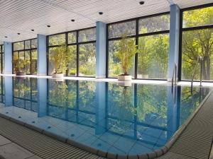 an indoor swimming pool with glass windows and a large swimming pool at Jutta Deluxe Apartment #301 in Bad Reichenhall