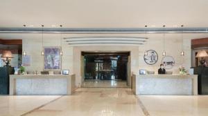 a lobby of a building with a person sitting at a counter at Zhuhai Jiali Hotel in Zhuhai