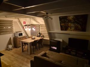 a living room with a table and a couch at Bois d' Hibou in Durbuy