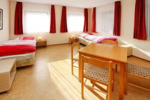 Apartments in Wieda في Wieda: غرفة نوم بسريرين وطاولة ومكتب