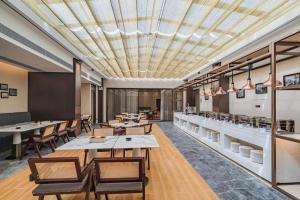 a restaurant with tables and chairs and a ceiling at Zhuhai Starlight Hotel in Zhuhai