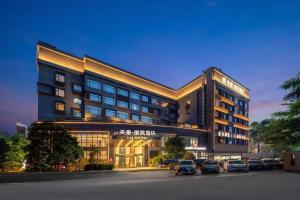 a large building with cars parked in a parking lot at Zhuhai Starlight Hotel in Zhuhai