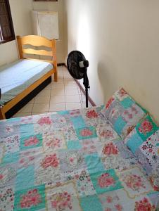 Hospedagem central في أرايال دو كابو: سرير عليه لحاف في غرفه