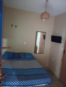 Hospedagem central في أرايال دو كابو: غرفة نوم بها سريرين ومرآة