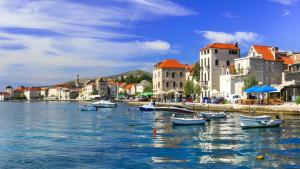 a group of boats in a body of water with buildings at Barać in Kaštela