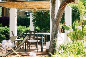 a patio with chairs and a table and a tree at Villino Eleonora in Parghelia