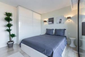 カンヌにあるAppartement Residence Athenaのベッドルーム(青いベッド1台、鉢植えの植物付)