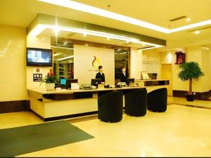 two people sitting at a desk in a lobby at Chengdu Huadu Times Hotel in Chengdu