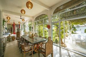 a dining room with a table and chairs and large windows at 4BR Villa for Families - 5 Min to Thomas Beach in Ungasan
