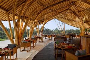Un restaurante con un gran techo de madera y mesas. en Akohara Buahan Village Retreat, en Payangan