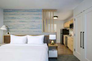 a bedroom with a bed and a kitchen at TownePlace Suites by Marriott Daytona Beach Oceanfront in Daytona Beach