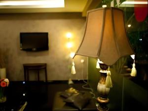 Hotel Ria في جوهور باهرو: وجود مصباح على طاولة في غرفة المعيشة