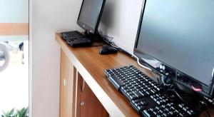 Place2Stay @ RH Plaza Hotel في Kampong Tabuan: شاشة كمبيوتر و لوحة مفاتيح و فأر على المكتب