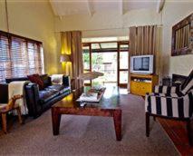 a living room with a couch and a coffee table at Delagoa Cottage Dullstroom in Dullstroom