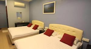 ein Hotelzimmer mit zwei Betten mit roten Kissen in der Unterkunft Hotel Station 18 in Kampong Kuala Punti + 173 Fotos