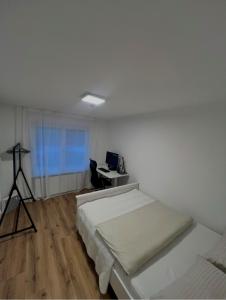 1 dormitorio con 2 camas y escritorio con ordenador en Ferienwohnung Südwind, en Hohentengen 6 fotos más