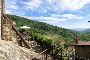 een trap met een paraplu op de top van een berg bij Il Borgo Dei Corsi - Charming Holiday Apartments in Ortignano Raggiolo
