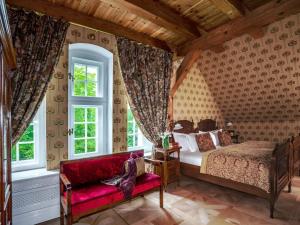 sypialnia z łóżkiem i czerwoną kanapą w obiekcie Pałac Ciekocinko Hotel Resort & Wellness w mieście Ciekocinko