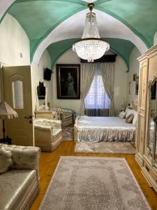 a bedroom with a large bed and a chandelier at Royal Transylvanian Castle - near Banffi in Gherla