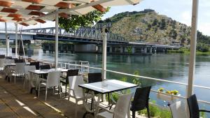 a restaurant with tables and chairs next to a river at Hotel Vataksi in Shkodër