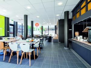 a dining room with tables and chairs in a restaurant at B&B HOTEL Paris Est Bobigny Université in Bobigny