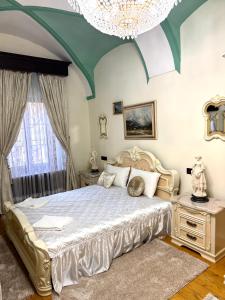 a bedroom with a large bed and a chandelier at Royal Transylvanian Castle - near Banffi in Gherla